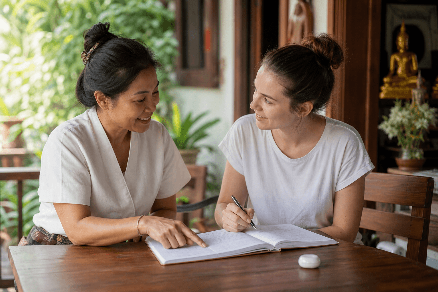 Friendly Thai tutor practicing beginner Thai phrases with an adult learner